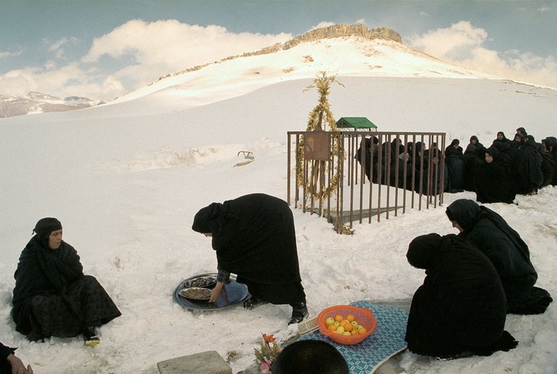 عباس عطار، ایران. استان لرستان. روستای علی آباد. زن ها در گورستان دهکده در برف سوگواری می کنند. میوه و شیرینی به عابرین تعارف می شد.، 1380